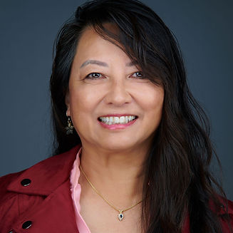 Asian woman with black hair, from the chest up wearing a maroon jacket and pink shirt